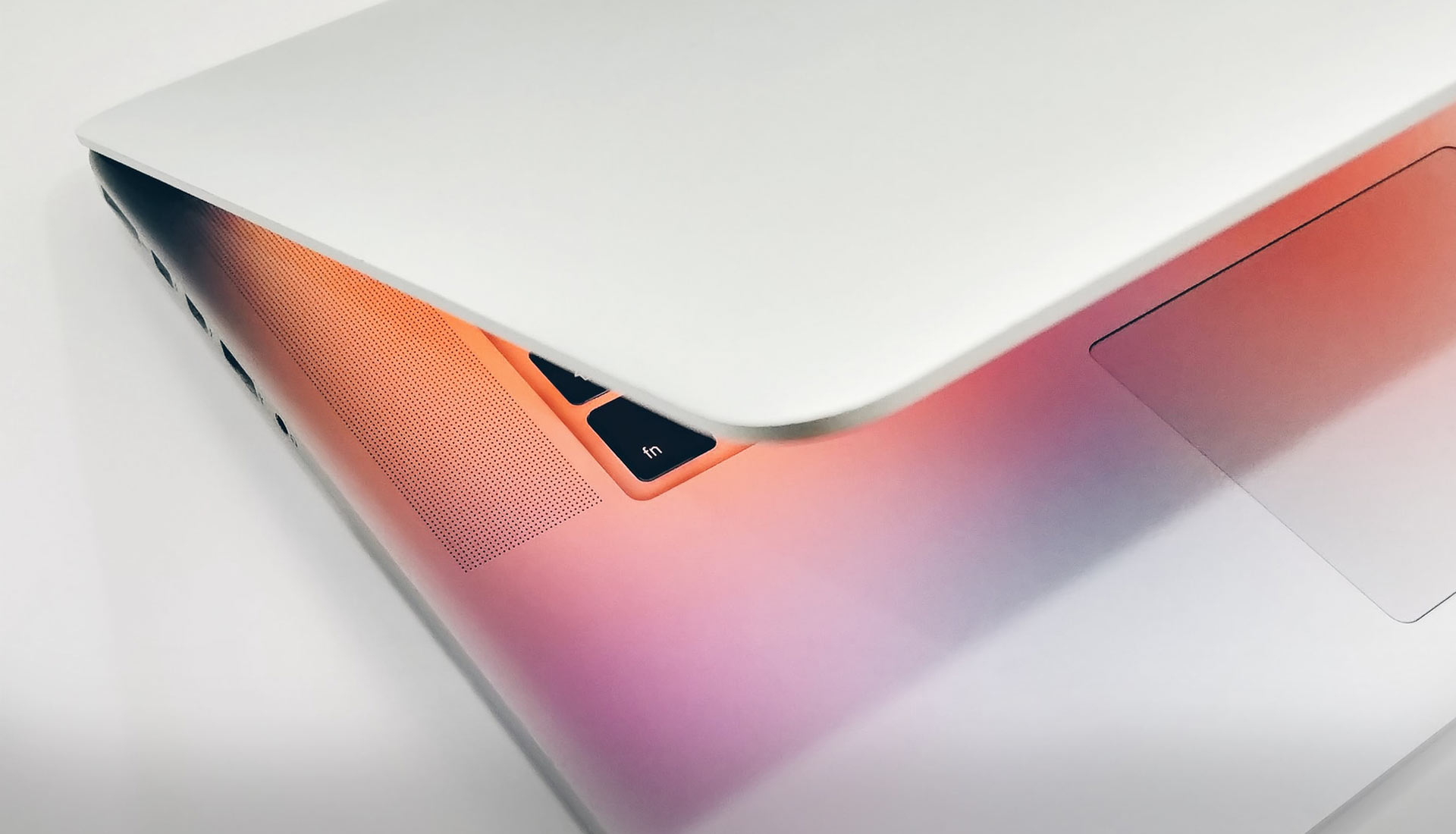 MacBook Pro half open with pinkish light